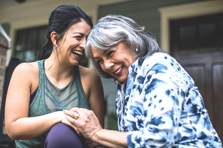 Woman and mother share a laugh while holding hands